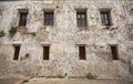 Old white cement wall with closed wooden windows. Royalty Free Stock Photo