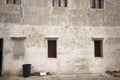 Old white cement wall with closed wooden windows. Royalty Free Stock Photo