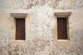 Old white cement wall with closed wooden windows. Royalty Free Stock Photo