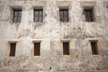 Old white cement wall with closed wooden windows. Royalty Free Stock Photo