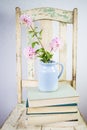 Old white chair with white background, flowers and books Royalty Free Stock Photo