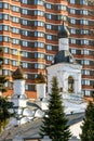 Old white Church on the background of a modern building. A combination of history and modernity Royalty Free Stock Photo