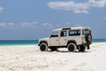 Old white coloured four-wheel drive off-road vehicle standing on a beach on the west coast of Fraser Island, Queensland. Royalty Free Stock Photo