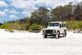 Old white coloured four-wheel drive off-road vehicle standing on a beach on the west coast of Fraser Island, Queensland.