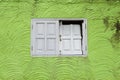 Old white damaged wooden window on design green wall pattern background Royalty Free Stock Photo