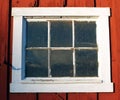 Old white framed window on red building