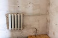 Old white heating radiator on a white dirty wall. old heating system Royalty Free Stock Photo