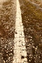 An old white line on a cracked asphalt road