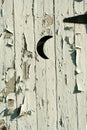 Old white outhouse moon door