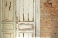 Old, white painted doors, closed, indoors with red brick walls Royalty Free Stock Photo