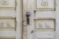 Old white peeling door. There is a lock and a handle in the form of a ball on the door Royalty Free Stock Photo