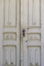 Old white peeling door. There is a lock and a handle in the form of a ball on the door Royalty Free Stock Photo