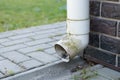 Old white plastic drain pipe on the brown brick wall Royalty Free Stock Photo