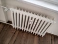 Old white radiator with an adjustment valve Royalty Free Stock Photo