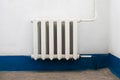 Old white radiator near the old dirty wall with dusty floor Royalty Free Stock Photo