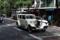 Old white Rolls Royce through the streets of the city in sunlight