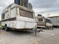 Old white rusty caravan trailers, mobile homes are parked