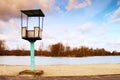 Old white and rusty metal lifeguard tower with chair on a beach. Frozen water level within witer Royalty Free Stock Photo