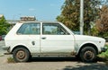 Old white rusty Yugo car made in Zastava Kragujevac parked on the street in the city