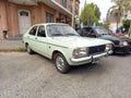 Old white 1970s Chrysler Dodge 1500 four door sedan parked in the street. Classic economy car