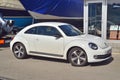 Old white small veteran car Volkswagen New Beetle parked