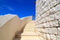 An old white stone staircase leads up to the tower of a medieval fortress. The element of architecture, design in house, cottage,