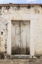 Old white timber door in the scuffed wall Royalty Free Stock Photo