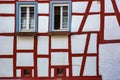Old white wall with red wooden beams and blue window frames Royalty Free Stock Photo