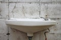 Old white washbasin on dirty wall Royalty Free Stock Photo