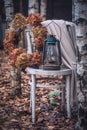 Old white wooden chair with a vintage lamp, wool plaid and handmade hyndragea wreath among birches Royalty Free Stock Photo