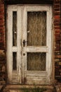 Old white wooden door in weathered dirty brick wall Royalty Free Stock Photo