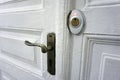 Old white wooden door with a handle and a modern lock