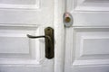 Old white wooden door with a handle and a modern lock