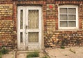 Old white wooden door in weathered dirty brick wall Royalty Free Stock Photo