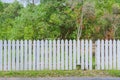 Old white wooden fence with a broken board Royalty Free Stock Photo