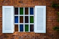 Old white wooden window with stained glass on brown brick wall background, Royalty Free Stock Photo