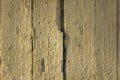 Old white yellow beige fence wall of wooden boards with cracked paint, vertical lines and shadows. rough surface texture Royalty Free Stock Photo