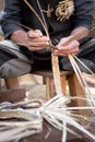 Old wicker craftsman with hands working in isolated foreground