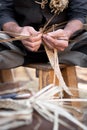 Old wicker craftsman with hands working in isolated foreground