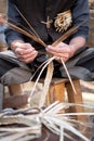 Old wicker craftsman with hands working in isolated foreground