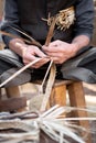 Old wicker craftsman with hands working in isolated foreground