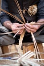 Old wicker craftsman with hands working in isolated foreground