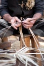 Old wicker craftsman with hands working in isolated foreground