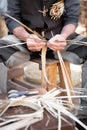 Old wicker craftsman with hands working in isolated foreground