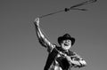 Old wild west cowboy with lasso rope. Bearded western man with brown jacket and hat catching horse or cow. Royalty Free Stock Photo