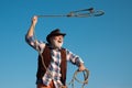 Old wild west cowboy with rope. Bearded western man throwing lasso with brown jacket and hat catching horse or cow. Royalty Free Stock Photo