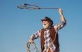 Old wild west cowboy with rope. Bearded western man throwing lasso with brown jacket and hat catching horse or cow. Royalty Free Stock Photo