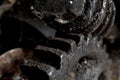 Old winch mechanism clogged with dirt and old grease, corroded black iron cogwhell and gear. Detail of teeth