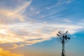 Old wind turbine with blue sunset sky and clouds at evening or twilight time. Royalty Free Stock Photo