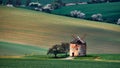 Old windmill on a background of yellow hills and white trees in Kunkovice.